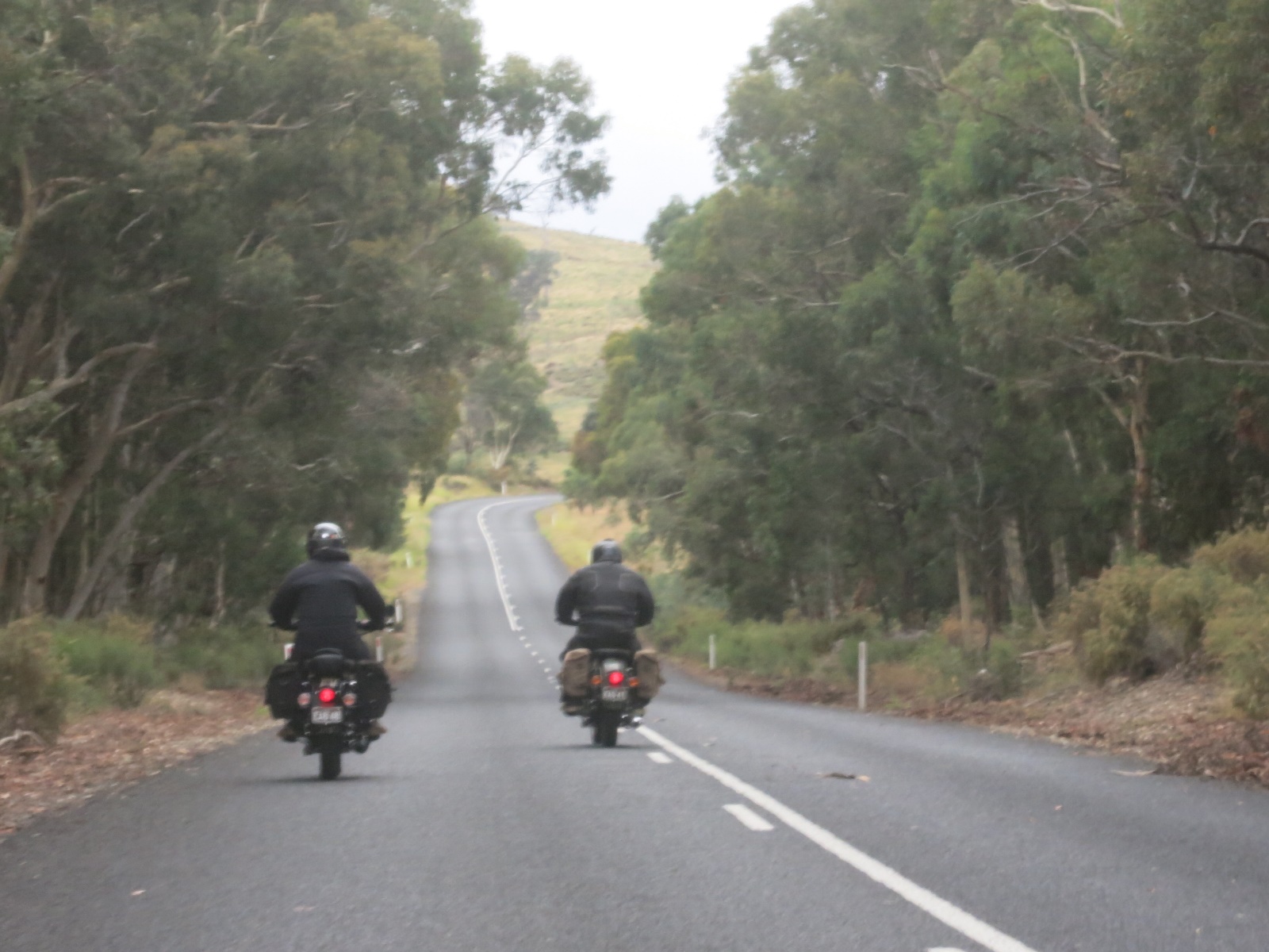 A couple of people ride motorcycles down a road

Description automatically generated with low confidence