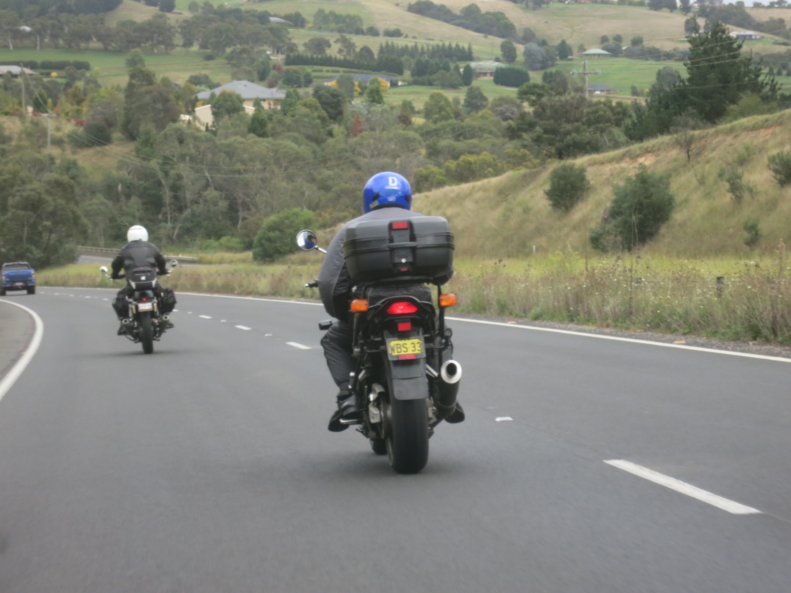 Two people riding motorcycles on a road

Description automatically generated with low confidence