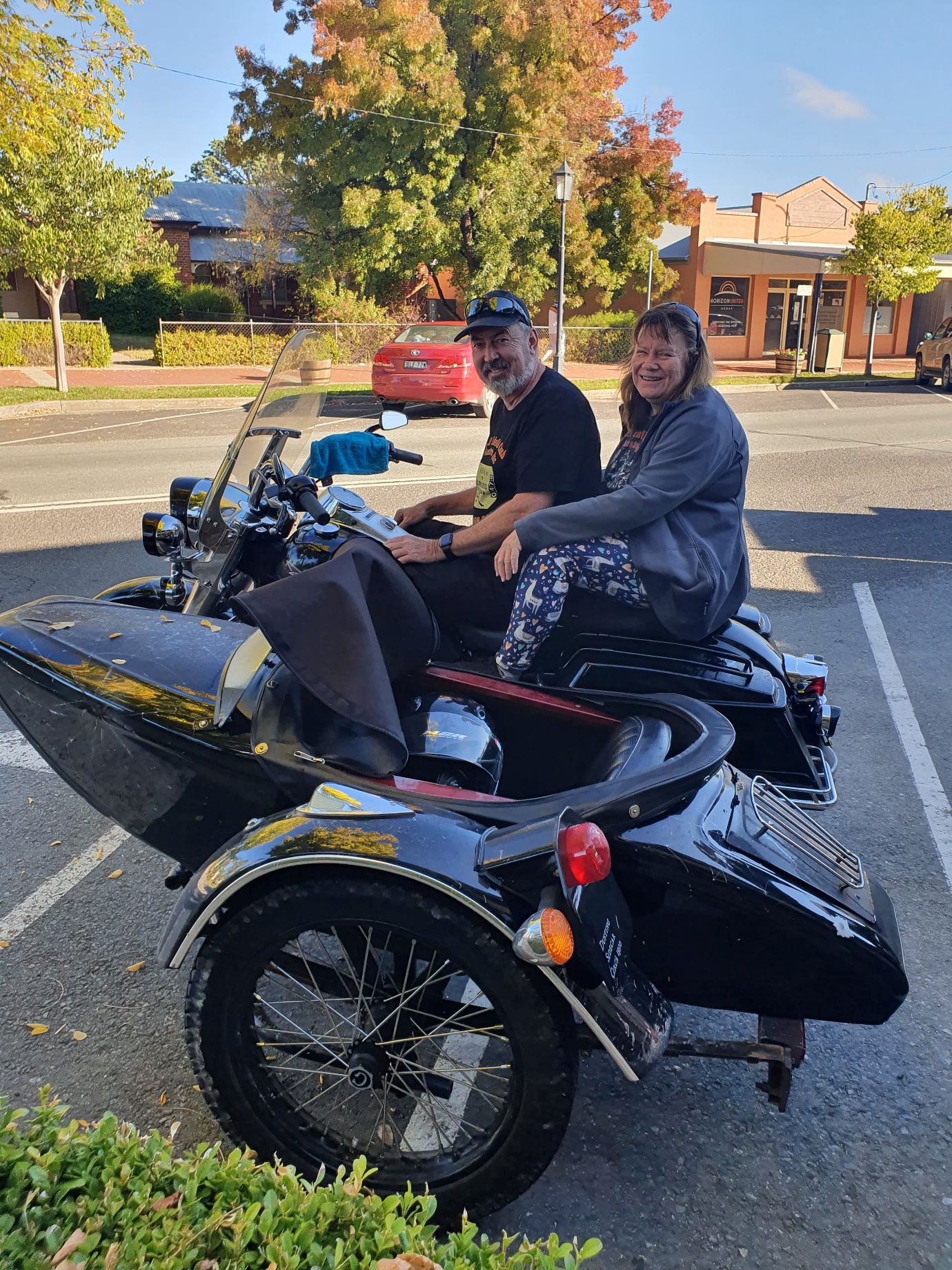 A couple sitting on a motorcycle

Description automatically generated with medium confidence