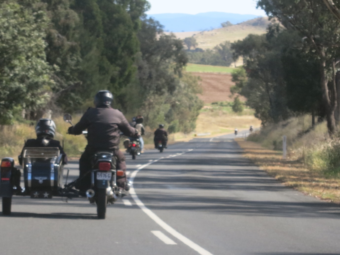A group of people riding motorcycles down a road

Description automatically generated with medium confidence
