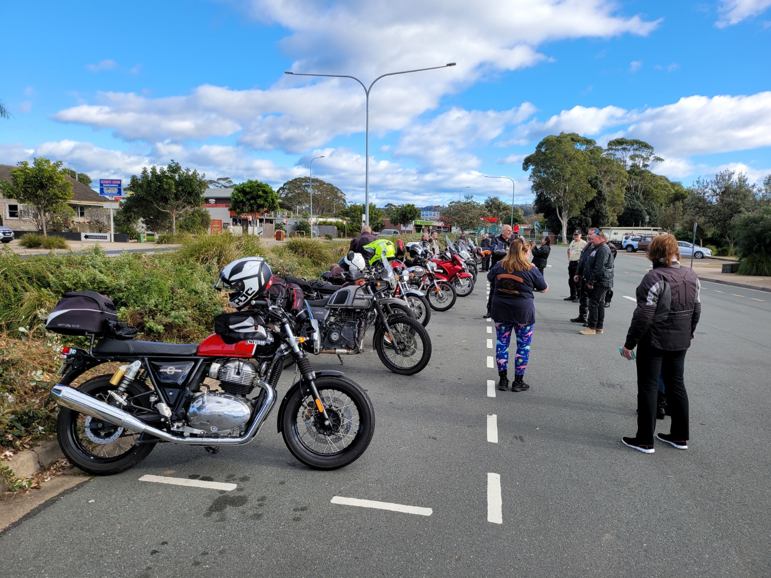 A group of motorcycles parked in a parking lot Description automatically generated with medium confidence