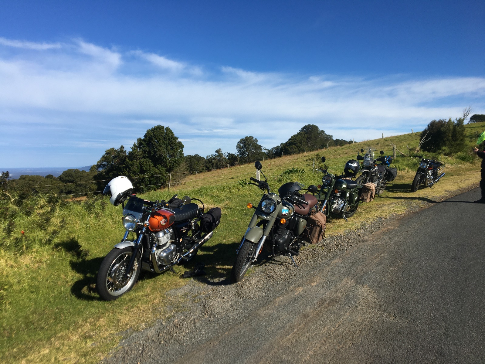 A group of motorcycles parked on a road Description automatically generated with low confidence