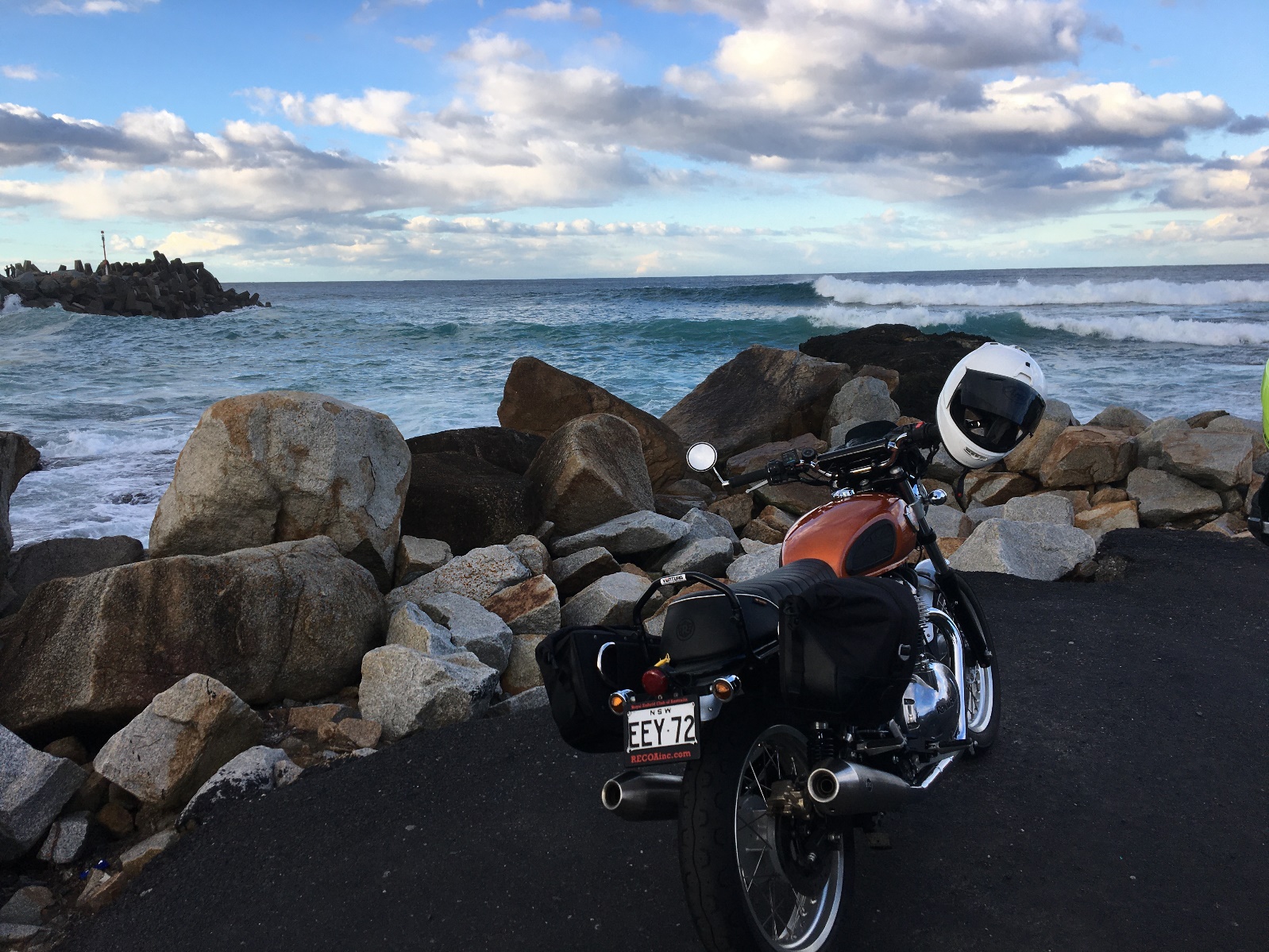 A motorcycle parked on a rocky beach Description automatically generated with medium confidence